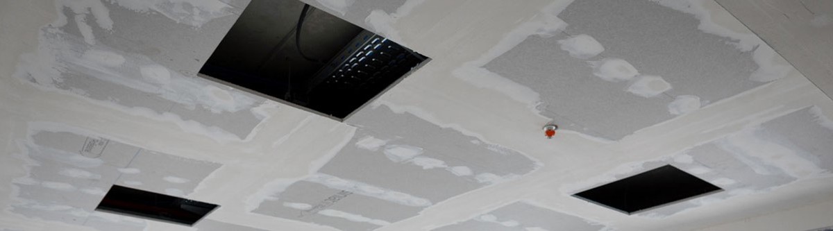 Izgled spuštenog plafona sa ventilacionim otvorima i nanesenom glet masom viđen iz ugla od 45 stepeni sa dna prostorije.